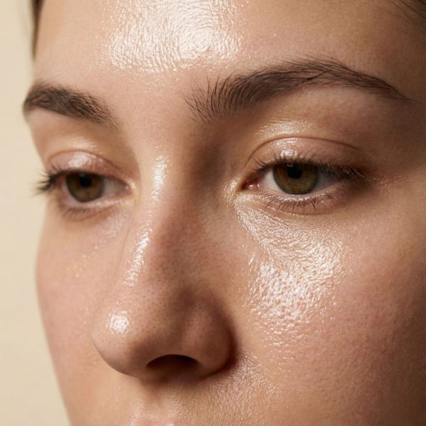 تصویر ماکرو و نمای نزدیک از بافت طبیعی پوست چرب و براق در ناحیه T-zone صورت با منافذ باز مشخص.